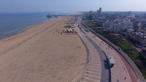 Aerial wide angle view of a modern curved beach promenade next to a massive Stock Footage 340042092