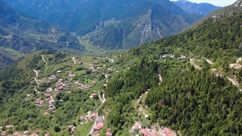 Aerial wide angle view of remote mountain village and forest valley Stock Footage 343945803