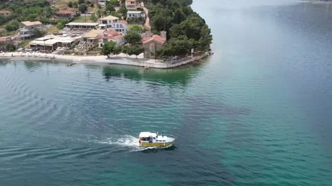 Aerial wide angle view of seaside village and cruising tourist boat Stock Footage 343944293