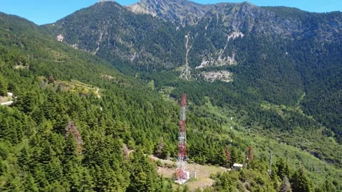 Aerial wide angle view of telecom tower above mountain forest valley Stock Footage 343946656