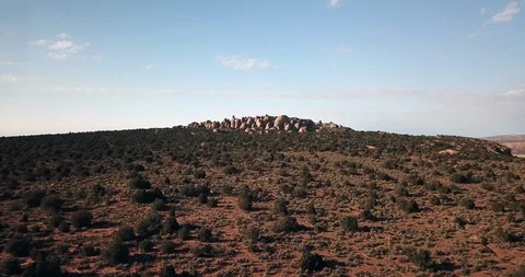 Aerial, wide dramatic establishing shot of sagebrush, trails, and distant rocks Stock Footage 120061936