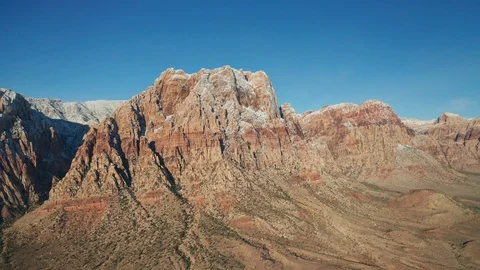 Aerial wide pullback shot of snow Mount Wilson mountain range in Red Rock Canyon Stock Footage 120617638