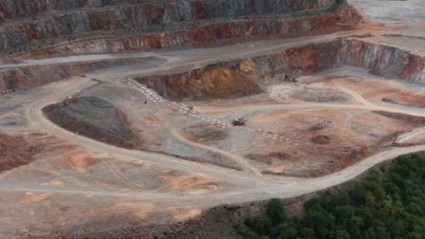 An aerial wide view of an active open pit mine site showing red earth, tiered Stock Footage 340897113