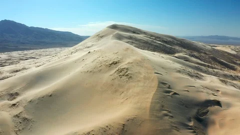 Aerial of Wind Blowing Sand Across Giant Sand Dunes Stock Footage 127005555