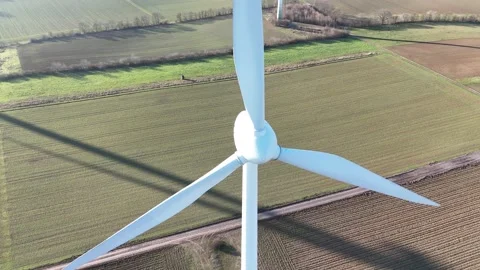 Aerial Wind Turbine Casting Shadow Across Agricultural Fields Stock-Footage 327974513