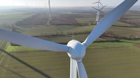 Aerial Wind Turbine Casting Shadow Across Agricultural Fields Stock Footage 327974689