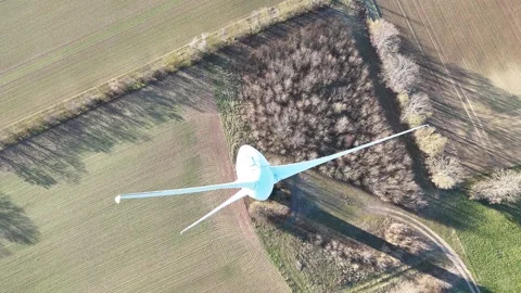 Aerial Wind Turbine Casting Shadow Across Agricultural Fields Video stock 327974716