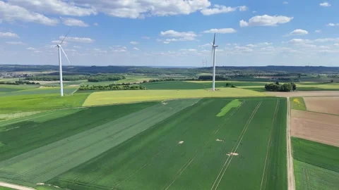 Aerial Wind Turbine Casting Shadow Across Agricultural Fields Video stock 327982868