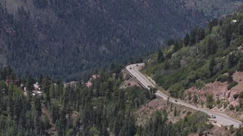 Aerial of winding mountain highway 145 through forested valley in Telluride Stock Footage 342000900