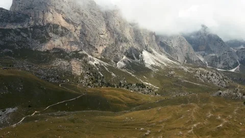 Aerial winding path below cloudy Dolomites cliffs Stock Footage 301243994