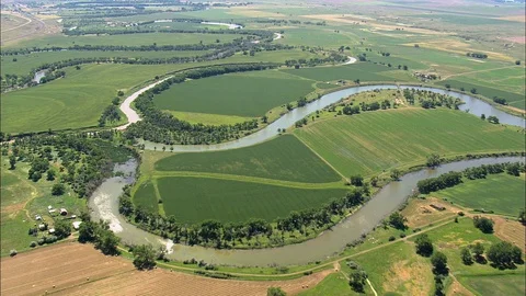 Aerial of winding river flowing through grass field, Very winding river in green Stock Footage 109459882