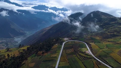 Aerial of winding road passing through patchwork field Stock-Footage 79679076