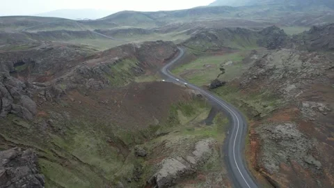 Aerial of winding road through volcanic hills with cars at Nesjavellir, Iceland Stock Footage 346552206