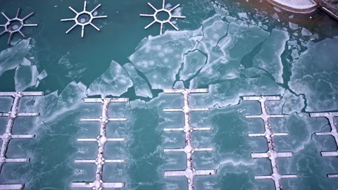 Aerial winter drone view of ice-covered harbor along Lake Michigan beside Stock Footage 331683499