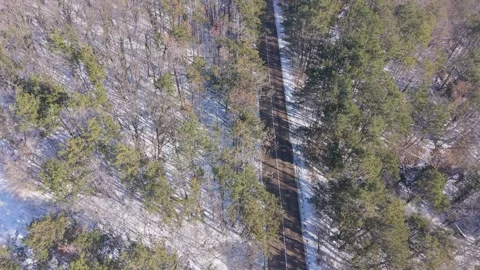 Aerial winter forest with hidden clearing and winding stream view Stock Footage 327351861