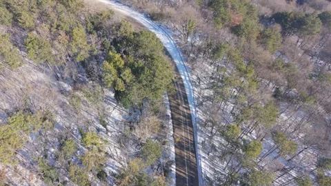 Aerial winter forest with hidden clearing and winding stream view Stock Footage 327351864