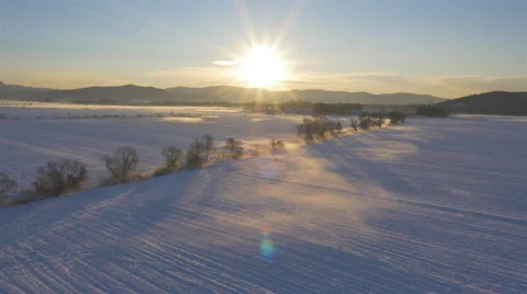 AERIAL: Winter landscape covered in snow at sunset Stock Footage