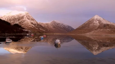 Aerial: Winter mountain reflections and boats on mirror flat icy water. 4K Stock Footage 88877451