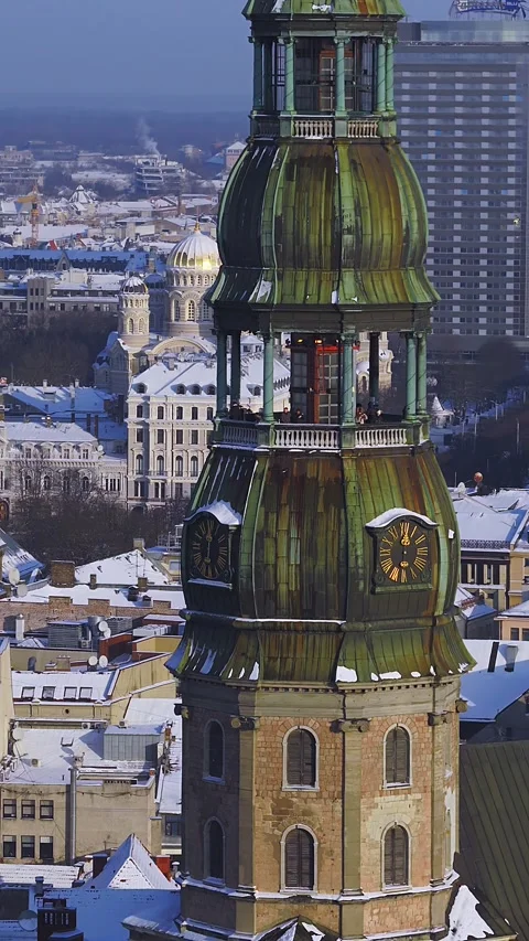Aerial winter pan over central Riga landmarks and St Peters clock tower Stock Footage 326819802