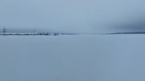 Aerial winter plain in Belarus with pylons, village, and deer Stock Footage 329927977