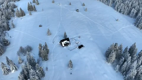 Aerial winter pull back from wooden cottage revealing mountains Stock Footage 336384443