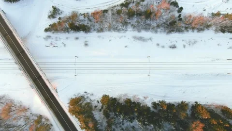 Aerial winter sunset top-down view of a road with cars and a railroad crossing 스톡 동영상 258715806