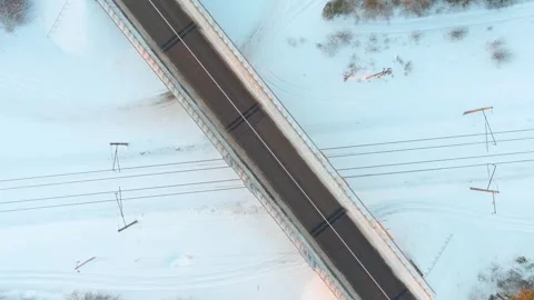 Aerial winter top-down sunset view of a road with cars and a railroad crossing. 스톡 동영상 290027553