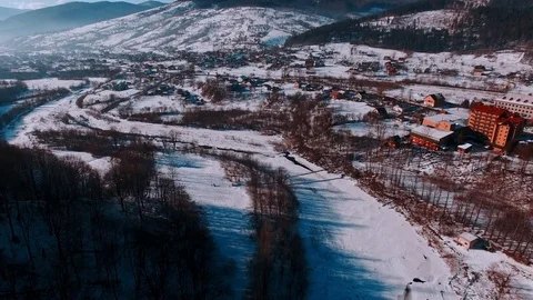 Aerial winter view high above rural village surrounded by pine tree forest Stock Footage 71976234