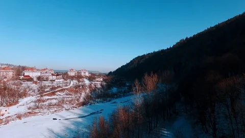Aerial winter view high above rural village surrounded by pine tree forest Stock-Footage 71982467