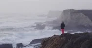 Aerial Of Woman Standing At Cliff Edge Over Ocean, Panther Beach Coastline Stock Footage
