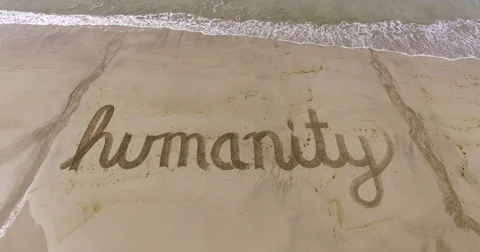 Aerial of the word humanity in the sand Stock Footage