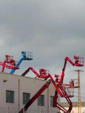 Aerial work platforms reaching high into grey sky Stock Photos