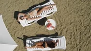 Aerial: Young Beautiful Model Girls Lie On Lounges, Posing In Designer Bikini Stock Footage