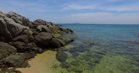 Aerial: Young lady is posing on the beach among stones. Thailand. Phuket. Stock Footage 76726639