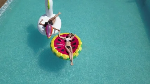 Aerial - Young sexy womans 20s laying and relaxed near pool at summer holiday Stock Footage
