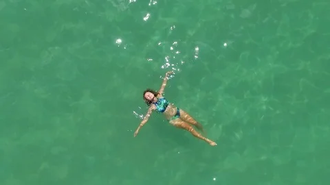 Aerial: Young Woman Swimming in Turquoise Sea Stock Footage