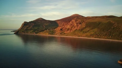Aerial of Yr Eifl Mountain Range in North Wales Above the Calm Ocean and Sunset 库存影片 154955749
