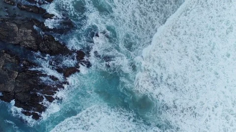Aerial Zoom In Shot Of Waves Breaking On Rocky Shore Stock Footage