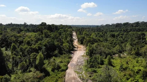Aerial Zoom to Vehicles Navigating Bumpy Jungle Road, Cambodia. Stock Footage 103538759