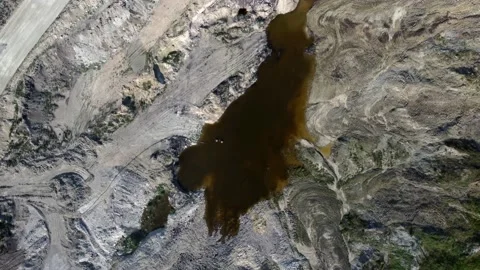 Aerial/Drone view of open mine pit coal mining activity. Water Pollution Stock Footage 165326505