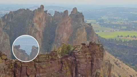 An aerialist bouncing on a slackline stretched between two rock spires 動画素材 228466700