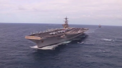 Aerials over an aircraft carrier and strike group on the high seas. Stock Footage