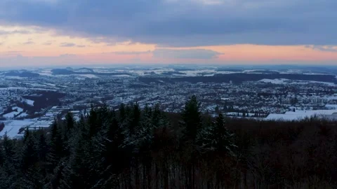 Aerials of Winter Forest Landscape Overlooking a Town at Sunset Time Stock Footage 331164094