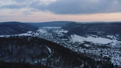 Aerials of Winter Forest Landscape Showing a Village in a Snowy Valley 動画素材 331164114