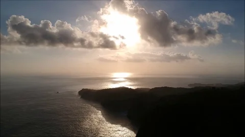 Aerial/top view of sunset, mountain, forest, jungle, ocean, clouds, sky Stock Footage 84050694