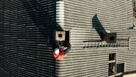 Aeriel shot pulling in on a construction worker operating a drill on a Stock Footage 161134500