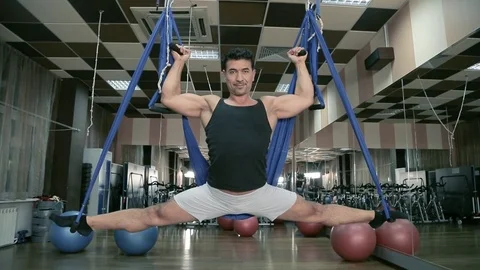 Aero yoga. Man doing the splits on the canvases. Stock Footage 80438066