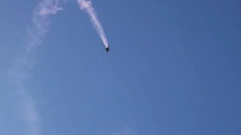 Aerobatic helicopter performing dynamic stunt dive maneuver with smoke trail Stock Footage 347000185