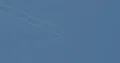 Aerobatics glider pulling white smoke lines from wings in the blue sky 4k or 4k+ Resolution