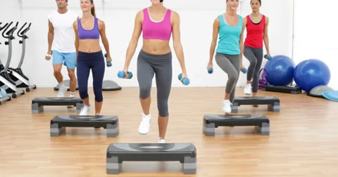 Aerobics class stepping together led by instructor and lifting dumbbells Stock Footage 36397839